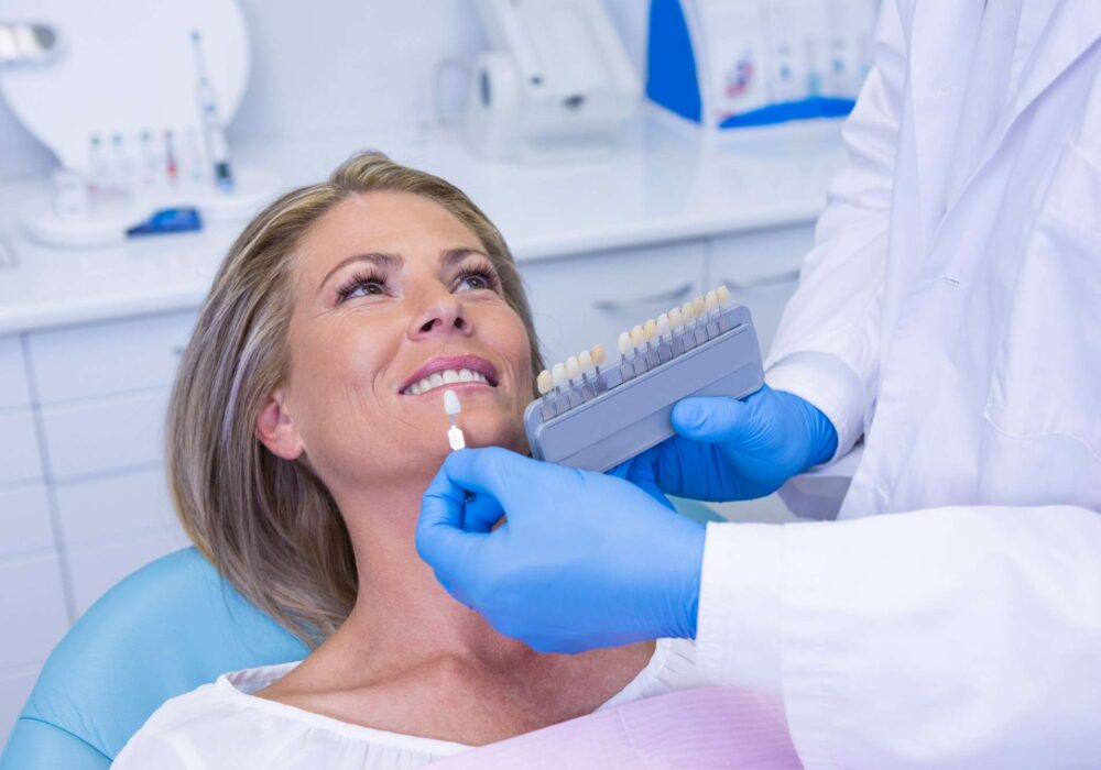 Doctor holding tooth whitening equipment by patient